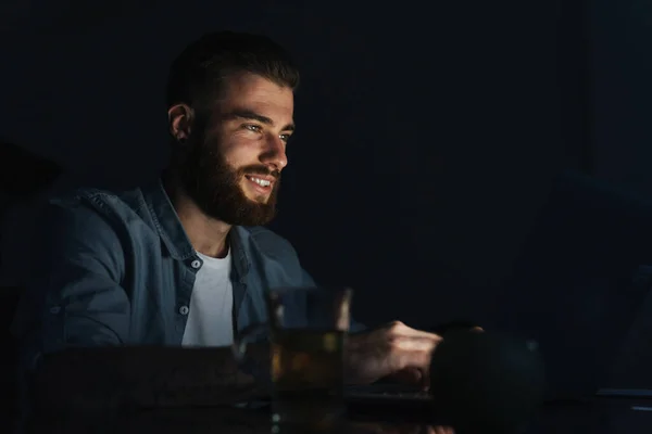 Glücklicher Junger Mann Arbeitet Laptop Während Nachts Drinnen Tisch Sitzt — Stockfoto
