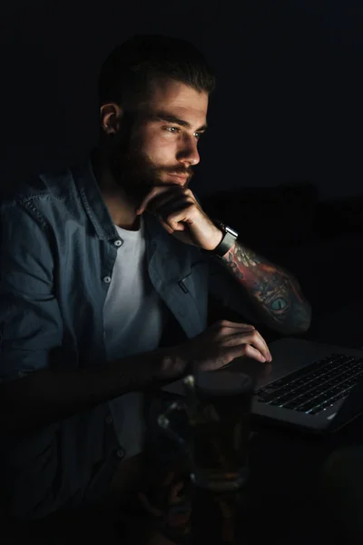 Selbstbewusst Denkender Junger Mann Arbeitet Laptop Während Nachts Tisch Sitzt — Stockfoto