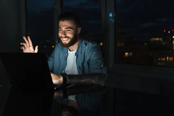 Χαμογελώντας Νεαρός Άνδρας Που Εργάζεται Φορητό Υπολογιστή Ενώ Κάθεται Στο — Φωτογραφία Αρχείου