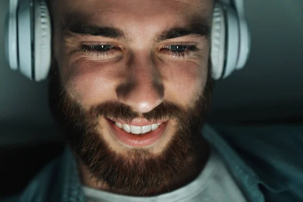 Zbliżenie Uśmiechniętego Brodatego Mężczyzny Noszącego Słuchawki Leżące Łóżku — Zdjęcie stockowe