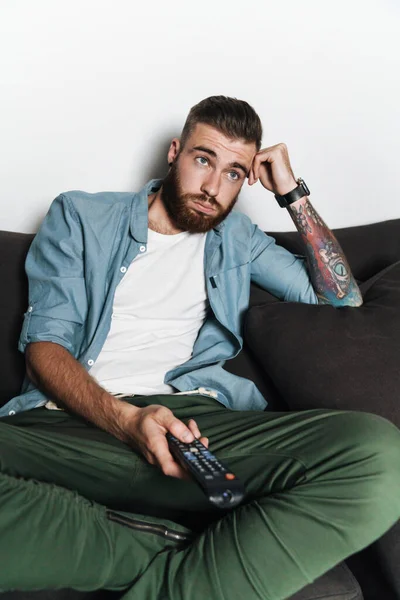 Attractive Bored Young Bearded Man Relaxing Couch Home Watching — Stock Photo, Image