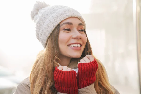 冬のジャケットを着た陽気な若い女の子と街の通りに立つ帽子の終わり — ストック写真