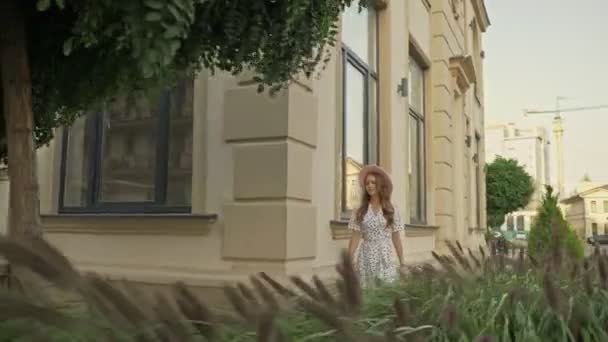 Egy Elégedett Fiatal Csinos Fehér Ruhában Gyönyörű Kalapban Sétálgat Utcán — Stock videók