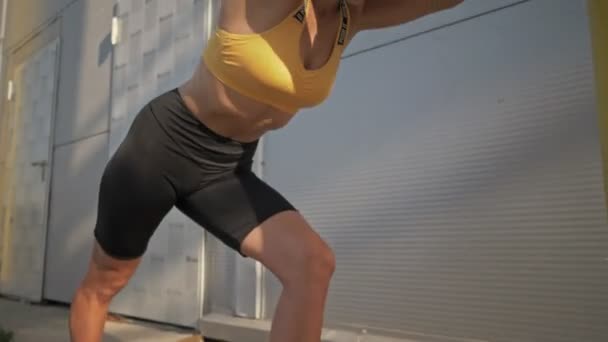アウトドアワークアウトをしながら彼女の足を伸ばすスポーツウェアの魅力的な若い女性 — ストック動画