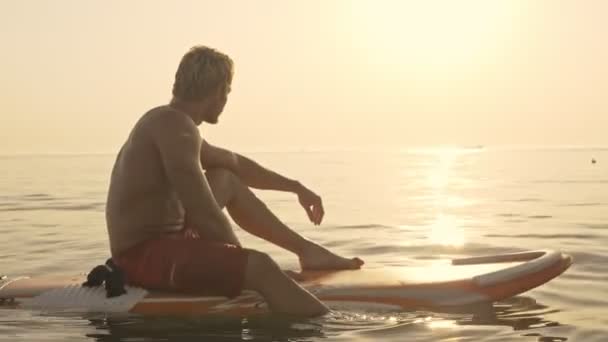 Side View Concentrated Muscular Surfer Sitting Surf Looking Away Sea — Stock Video