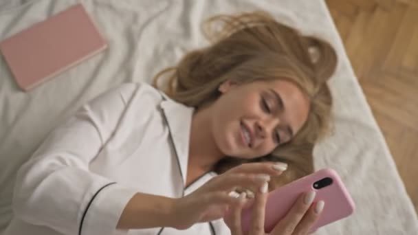 Une Jeune Femme Souriante Heureuse Pyjama Blanc Utilise Son Smartphone — Video