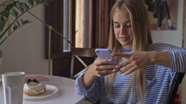 Een Tevreden Lachende Jonge Vrouw Gebruikt Haar Smartphone Terwijl Woonkamer — Stockvideo