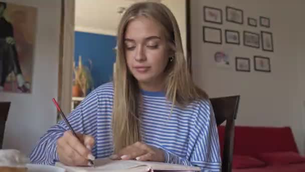 Una Joven Rubia Agradable Enfocada Está Haciendo Algo Cuaderno Mientras — Vídeos de Stock