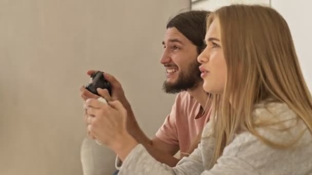 Een Emotioneel Jong Liefdevol Paar Bank Speelt Videospelletjes Met Joystick — Stockvideo