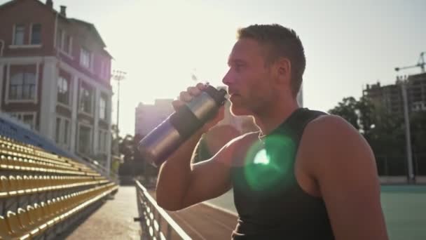 Een Rustige Jonge Fitte Sportman Drinkt Water Uit Een Sportfles — Stockvideo