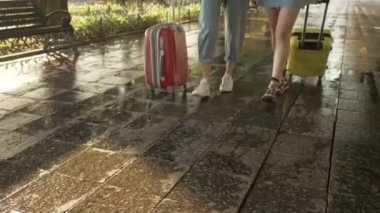 İki güzel genç turist kız ellerinde bir haritayla sokaklarda bavullarıyla dolaşıyorlar.