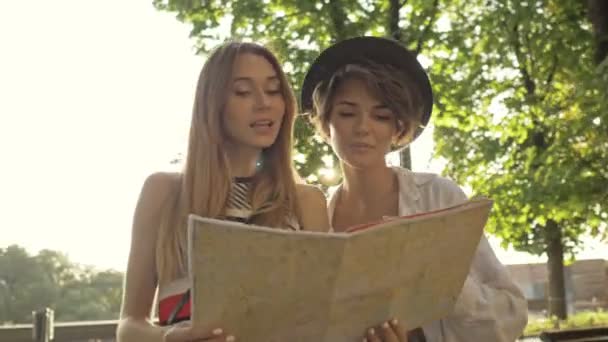 两个严肃的年轻旅游姑娘在街上散步时正在探索城市地图 — 图库视频影像