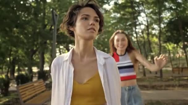 아름다운 소녀가 공원에서 친구를 껴안기 달려가고 있습니다 — 비디오