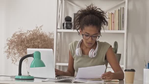 Mujer Africana Bastante Concentrada Anteojos Leyendo Documentos Escribiendo Algo Computadora — Vídeos de Stock