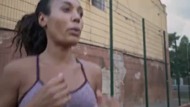 Μια Εστιασμένη Αφροαμερικάνα Γυναίκα Στα Αθλητικά Κάνει Προθέρμανση Ενώ Πηδάει — Αρχείο Βίντεο