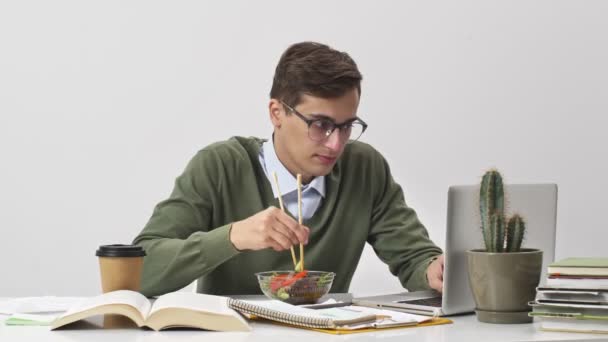Een Gefocuste Jonge Zakenman Eet Diner Tijdens Werktijd Zittend Aan — Stockvideo
