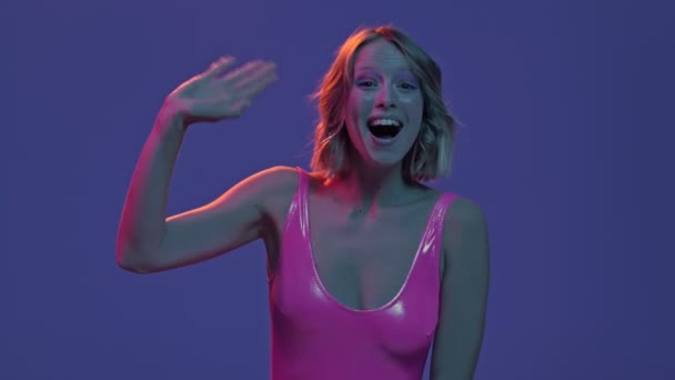 Surprised Young Woman Waving Her Hand Camera Isolated Purple Neon — Stock Video