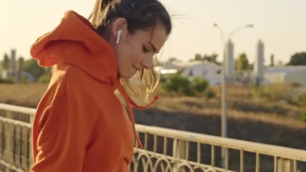 Una Joven Feliz Con Una Sudadera Naranja Está Saltando Con — Vídeos de Stock