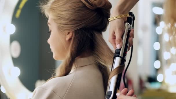 Ein Professioneller Friseur Frisiert Mit Einem Bügeleisen Während Einem Kunden — Stockvideo