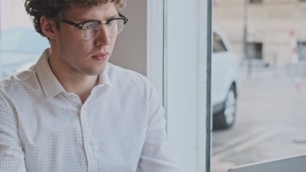 Yoğunlaşmış Genç Bir Işadamı Arkadaşıyla Birlikte Kafede Kahve Içerken Dizüstü — Stok video