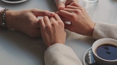 Çiftin ellerinin bir arada olduğu yakın çekim görüntüsü. O tarihte kafede kapalı bir yerde.