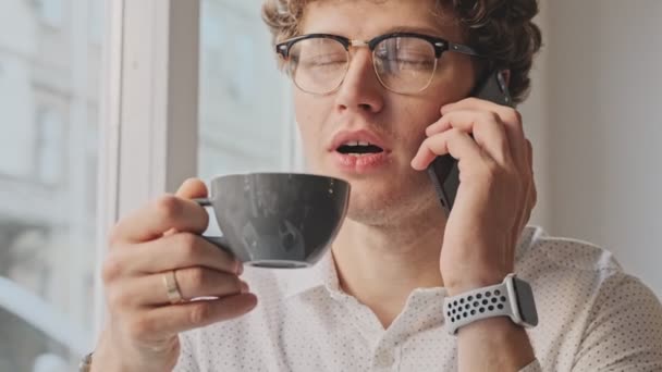 Позитивный Улыбающийся Кудрявый Парень Очках Наслаждается Кофе Помещении Кафе — стоковое видео