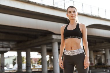 Dışarıda poz veren genç ve güzel bir spor spikeri..