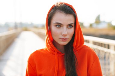 Dışarıda poz veren genç ve güzel bir spor spikeri..