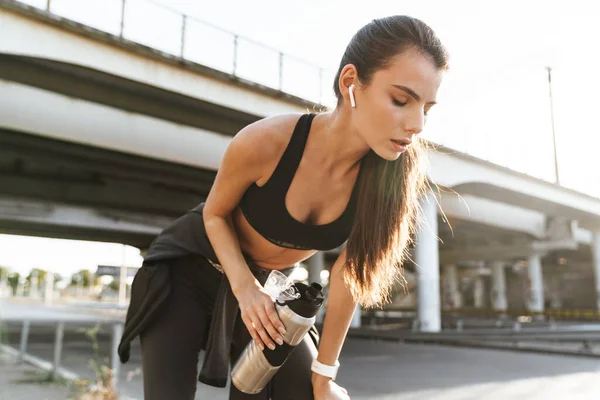 Beeld Van Een Serieuze Sportieve Fitnessvrouw Buiten Luisterend Naar Muziek — Stockfoto