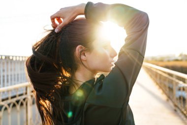 Açık havada poz veren oldukça güzel, genç, inanılmaz bir spor spikeri resmi..