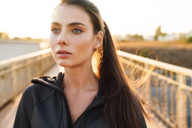 Açık havada poz veren oldukça güzel, genç, inanılmaz bir spor spikeri resmi..