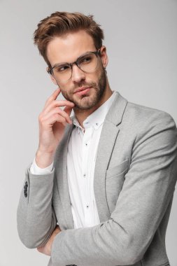 Kameraya poz veren beyaz gözlüklü beyaz bir gencin portresi.