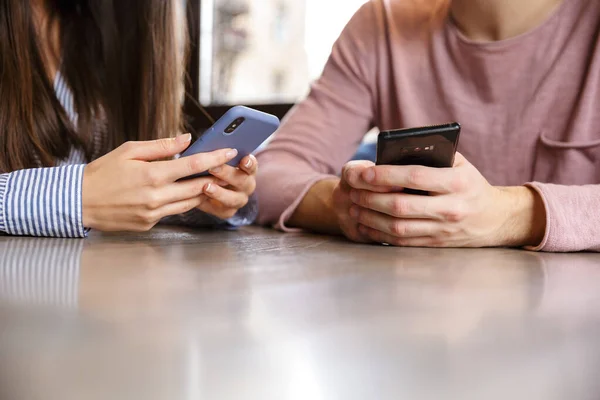 Close Jovem Casal Usando Telefones Celulares Enquanto Sentado Mesa Café — Fotografia de Stock