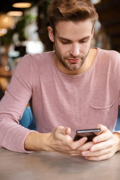 Vonzó Fiatalember Mobiltelefont Használ Miközben Kávézóasztalnál — Stock Fotó