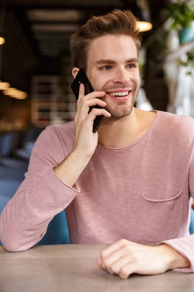 Attractive Smiling Young Man Talking Mobile Phone While Sitting Cafe — Stock Photo, Image