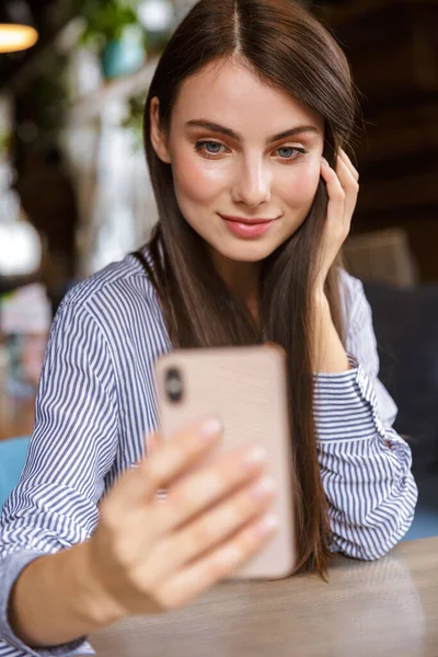 Linda Sorridente Jovem Morena Tomando Uma Selfie Enquanto Sentado Café — Fotografia de Stock