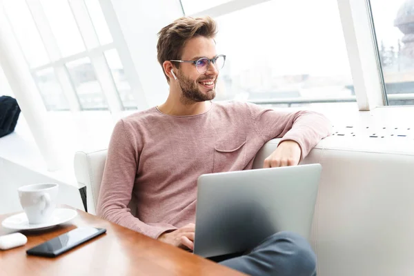 Image Young Bearded Man Wearing Earbuds Working Laptop Computer Window — Stock Photo, Image