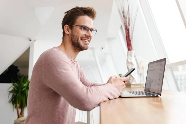 Imagen Joven Barbudo Con Anteojos Trabajando Ordenador Portátil Por Ventana — Foto de Stock