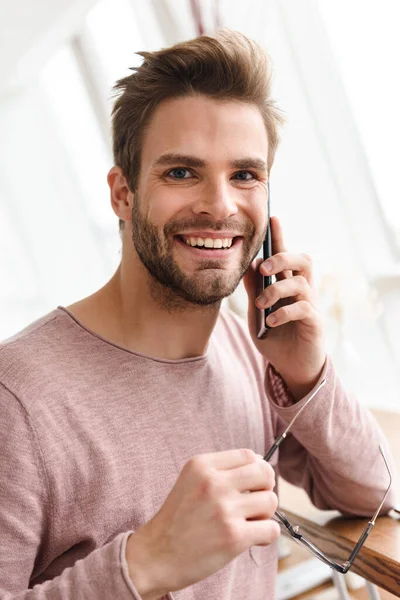 Imagem Jovem Barbudo Segurando Óculos Falando Celular Enquanto Estava Sobre — Fotografia de Stock