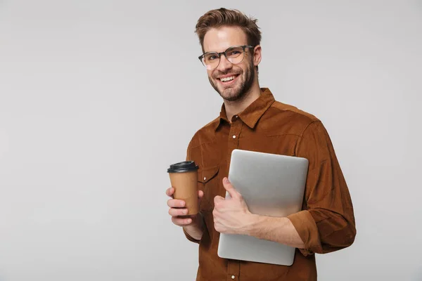 Портрет Веселого Молодого Человека Очках Позирующего Ноутбуком Бумажной Чашкой Белом — стоковое фото