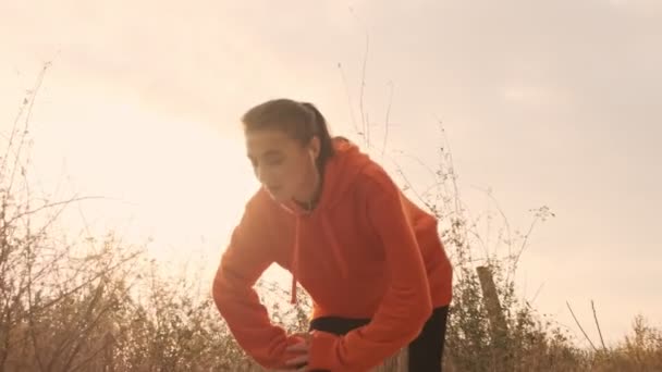 Kulaklıklı Güzel Atletik Bir Kadın Bacaklarıyla Isınıyor Deniz Kıyısına Bakıyor — Stok video