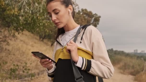 Konzentrierte Hübsche Athletische Frau Mit Kopfhörer Und Smartphone Die Mit — Stockvideo