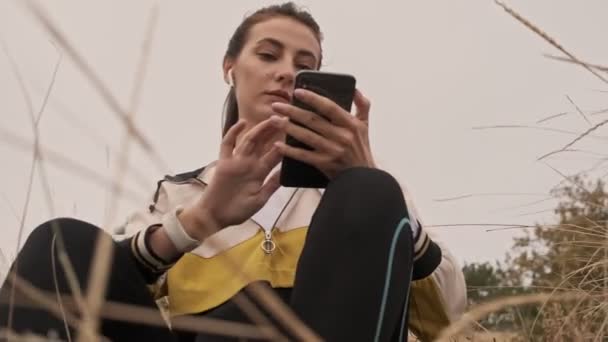 Veja Abaixo Carefree Mulher Atlética Bonita Fones Ouvido Usando Smartphone — Vídeo de Stock