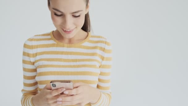 Una Joven Agradable Está Utilizando Teléfono Inteligente Aislado Sobre Fondo — Vídeo de stock