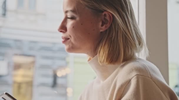 Piękna Młoda Blondynka Używa Telefonu Komórkowego Siedząc Kawiarni Pijąc Kawę — Wideo stockowe