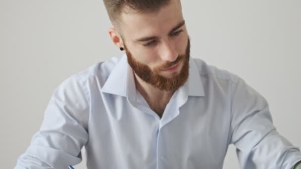 Atractivo Joven Barbudo Con Una Camisa Está Escribiendo Algo Sentado — Vídeo de stock