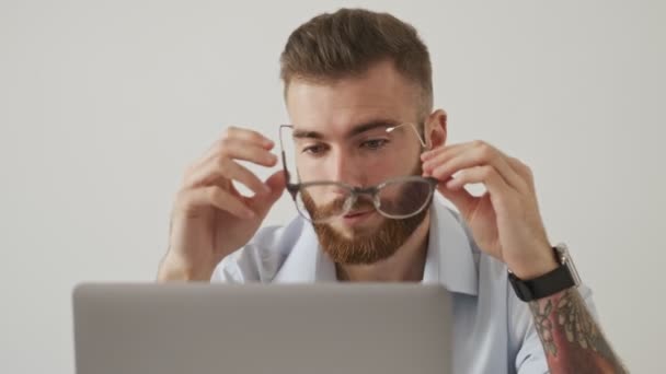 Egy Fáradt Fiatal Szakállas Férfi Levette Szemüvegét Miközben Laptopjával Fehér — Stock videók