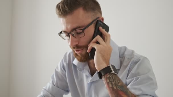 Egy Vonzó Szemüveges Üzletember Beszél Telefonon Miközben Papíralapú Dokumentumokkal Dolgozik — Stock videók