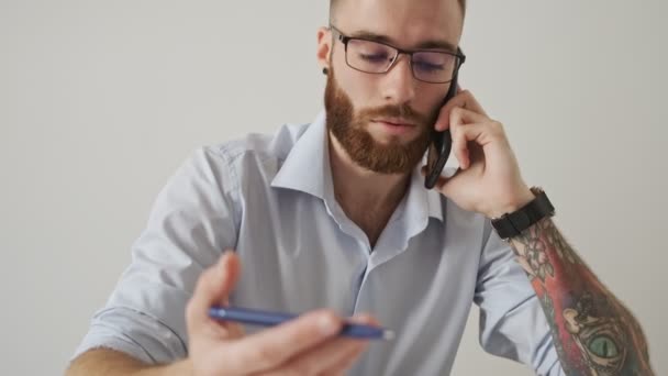 Zaměřený Mladý Podnikatel Brýlemi Mluví Telefonu Během Práce Papírovými Dokumenty — Stock video