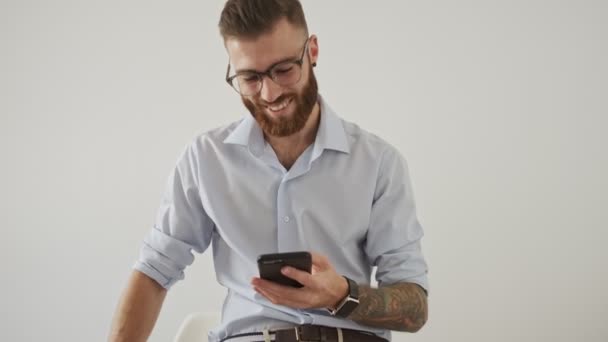Gözlüklü Yakışıklı Genç Bir Işadamı Telefonu Tutuyor Beyaz Ofiste Kameraya — Stok video